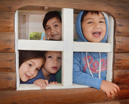 niños jardín pelvin jugando en casita de madera
